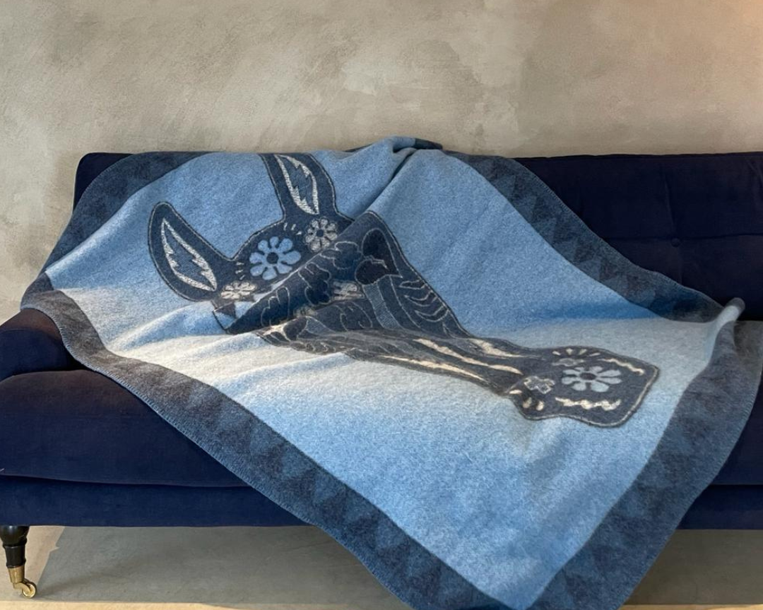 Blue wool blanket with image of horse on a sofa