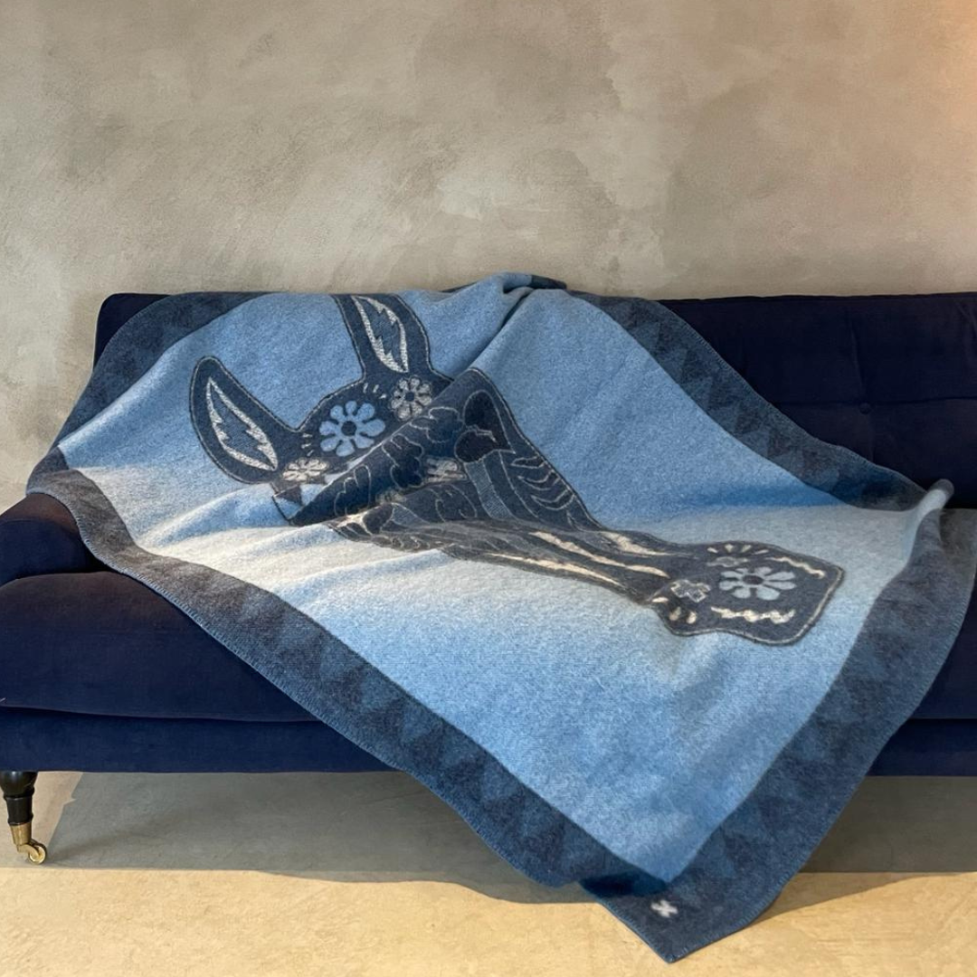 Blue wool blanket with image of horse on a sofa